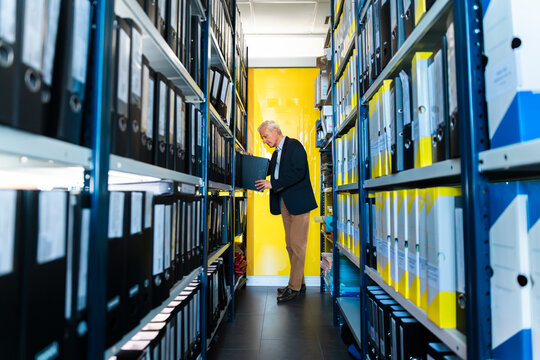 Businessman searches for a document in the office archive