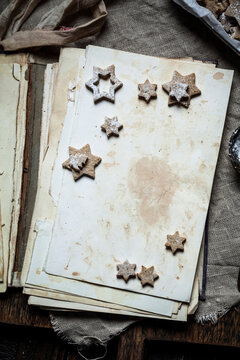 Home-baked Christmas cookies with powdered sugar on old book