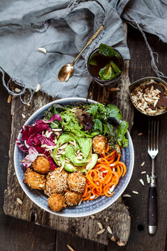 Rainbow salad bowl with carrots, lettuce, avocado, millet falafel and Moroccan mint tea