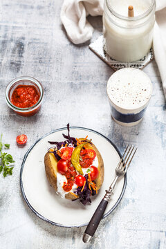 Kumpir, Turkish baked potato with raw vegetable salad, carrot, tomato, yogurt sauce, ajvar and Ayran