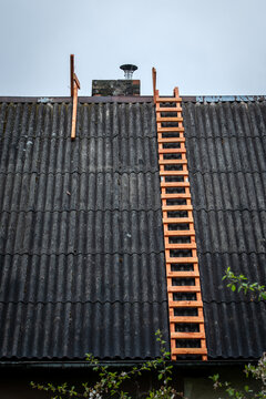 Wooden Ladder Positioned on Old Roof for Chimney Repair Work