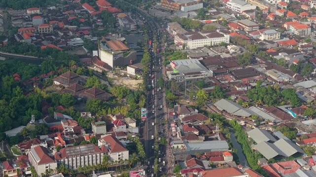 Aerial view of the Statue of Dewa Ruci roundabout with busy traffic and dense urban development in Kecamatan Kuta, Bali, Indonesia.