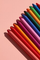 Obraz premium Angled closeup of multicolored pencil tips on blush pink background for design poster banner and artistic stationery flatlay