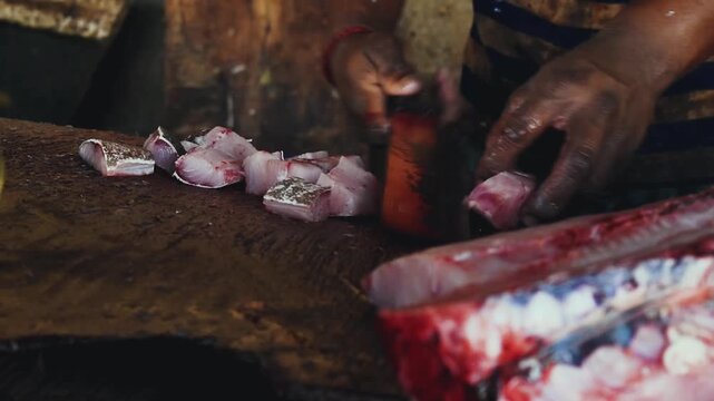 Hands Cutting Fresh Fish Fillet with Knife on Wooden Board