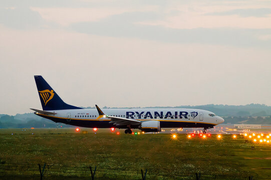Horizontal dusk aviation photo of Ryanair airplane near runway lights side view in Krakow, Poland real life photography