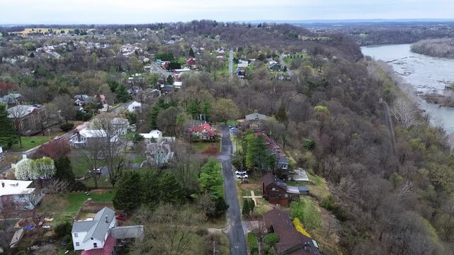 Expansive residential enclave spreads across Bolivar Heights ridge above Potomac River bend. Historic metal roof dwellings dot rolling wooded landscape in Harpers Ferry, West Virginia