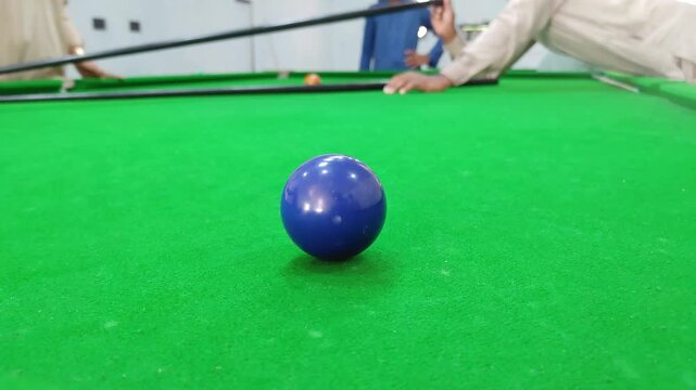 Blue snooker ball close up. Isolated ball on green felt table. Billiards match background.