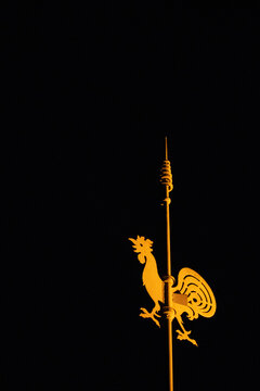 Silhouette dor&eacute;e d&rsquo;un coq d&eacute;coratif &eacute;clair&eacute;e dans la nuit noire