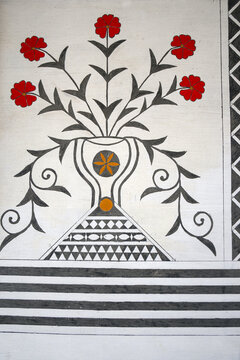 Close-up of Genoese floral symbols with red blossoms in a vase on a house facade in Pyrgi, Chios
