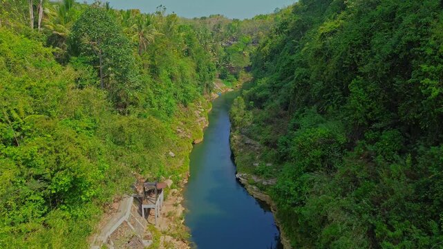 Aerial view of the lush green canyon and river surrounding Sri Gethuk Waterfall in Yogyakarta, Special Region of Yogyakarta, Indonesia.