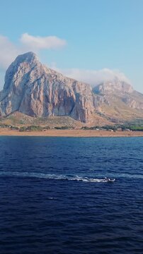 Vertical Aerial Slow Tracking View of Speedboat and Mount Monaco in San Vito Lo Capo, Sicily