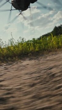 Close-up of a bicycle wheel spins as a cyclist rides over dusty, rough terrain on a sunny day, the visible spokes emphasize the sport of cycling, relating to outdoor recreation and off-road travel