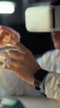 A researcher in a modern lab, wearing a virtual reality headset, interacts with an advanced robotic hand, focusing on technology and robotics research for enhanced user interaction capabilities