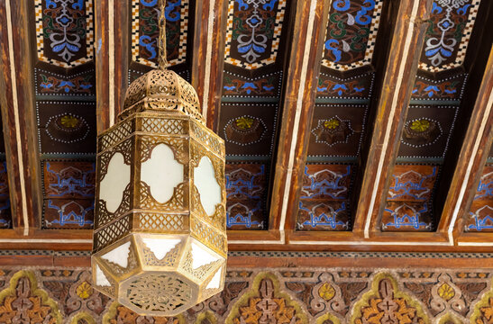 Traditional Brass Lantern Suspended Beneath an Elaborately Painted Wooden Ceiling in Marrakech