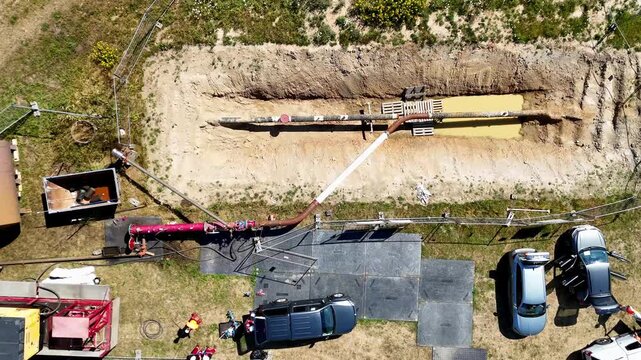 Pipeline repair occupies the scene.
Excavation exposes buried infrastructure.
Construction equipment surrounds the trench.
Drone footage captures industrial maintenance.