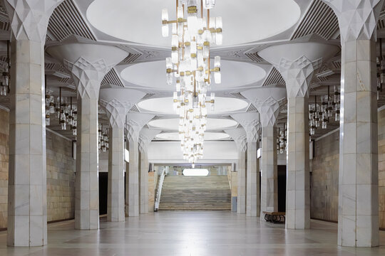 Ornate marble interior of Mustaqillik Maydoni metro station in Tashkent with crystal chandeliers and geometric columns. Ideal for travel, architecture, and urban design publications.
