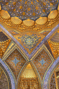 Ornate golden ceiling of Ak Saray Mausoleum in Samarkand with intricate muqarnas and floral arabesques. Stunning example of Timurid Islamic interior decoration ideal for travel cultural heritage.