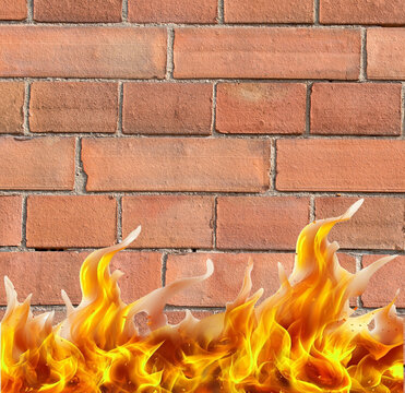 Flammen vor einer Ziegelsteinwand symbolisch f&uuml;r eine Brandmauer