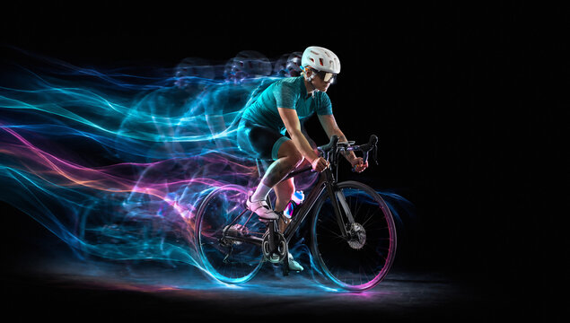 Cyclist rides at high speed surrounded by luminous blue and magenta energy streams. Concept of cycling gear, race analytics and active lifestyle ads.