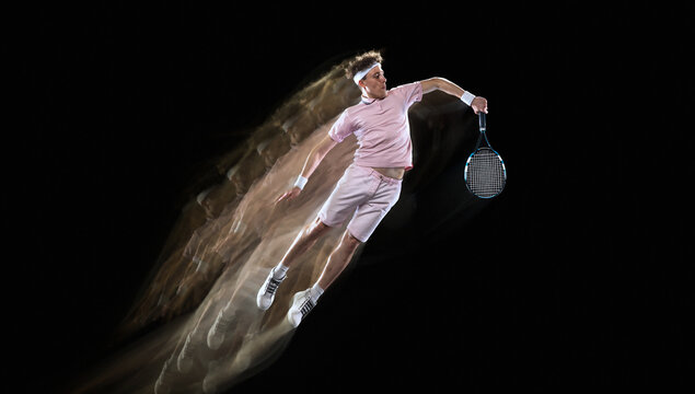 Male tennis player serves with sweeping golden energy trail on dark background. Concept of tennis equipment, athlete performance and tournament ads.