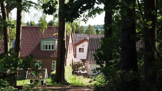 Traditional danish house seen from a dark forest path