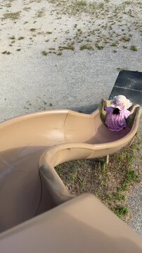 公園の滑り台をすべる女の子