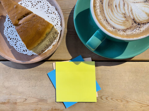 Coffee and cake with colorful blank sticky notes on a wooden table, representing work, creativity, planning, study, and everyday productivity.