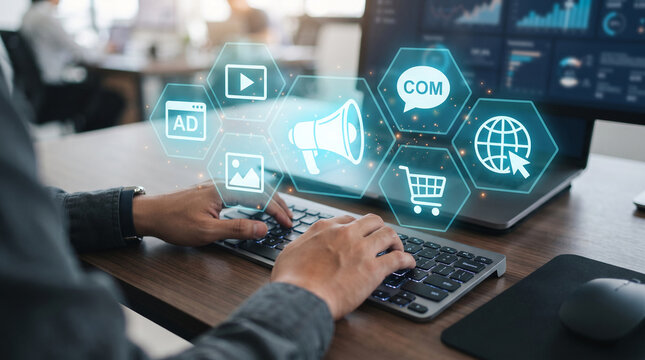 Digital marketing icons floating over a person typing, representing online promotion, advertising, and e-commerce concepts