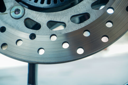 Motorcycle Disc Brake System Close Up with Steel Rotor and Black Wheel Rim for Automotive Maintenance and Transport Concept