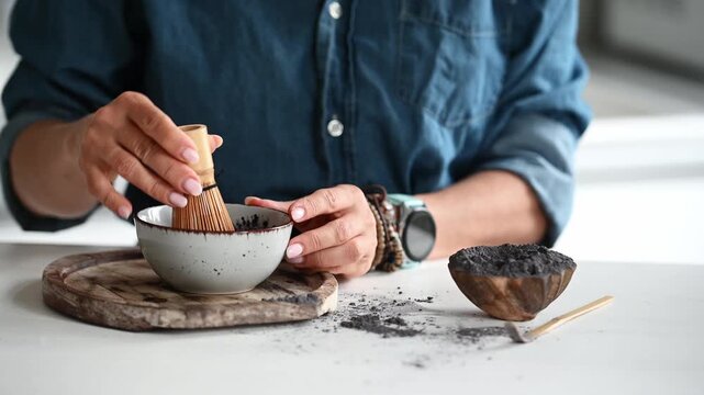 Woman Whisks And Serves Blue Matcha Tea In A Bowl