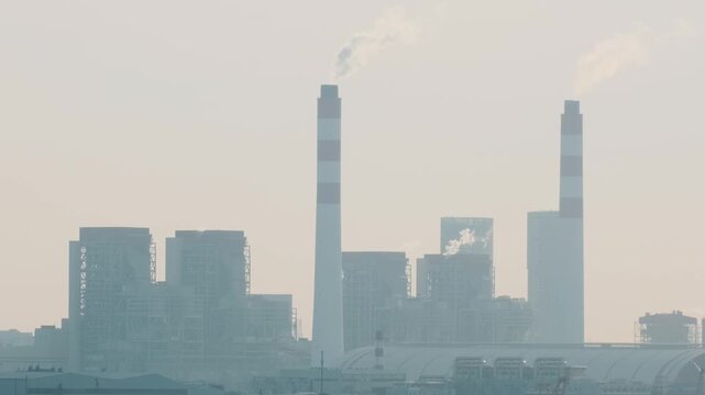 Industrial power plant with smokestacks and cargo port infrastructure near Shanghai city waterfront, China. Energy production, logistics, global trade, heavy industry and economic development