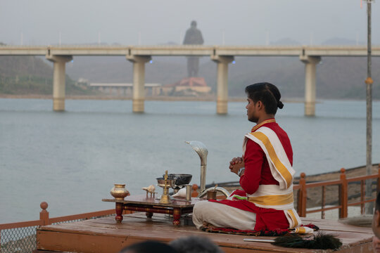 Priest offers Narmada aarti before the Statue of Unity capturing spiritual devotion, faith, culture and tourism along the serene riverside during sacred evening ritual ceremony at Ekta Nagar, Gujarat.