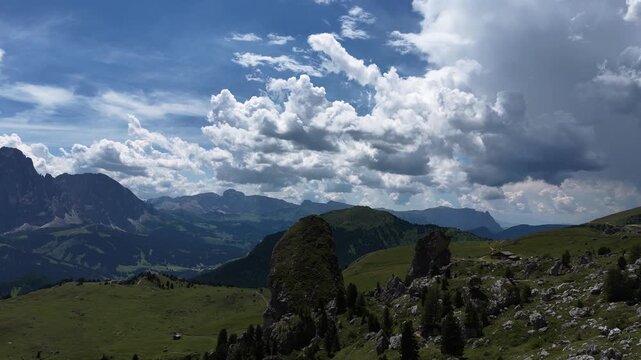 View of beautiful landscape in the Alps with fresh green meadows and mountain tops in the background on a sunny day with blue sky and clouds in summertime. Alpe di Cisles, Seceda Ridgeline, Dolomiti ,