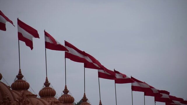 Swaminarayan Temple at Nilkanth Dham in Poicha showcases sacred Hindu architecture with fluttering flags, creating a spiritual setting for meditation, devotion, worship, peace and Hinduism traditions.