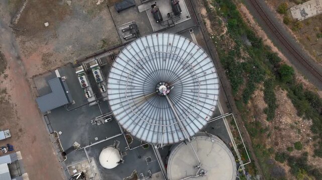 Rising aerial looks down on bioreactor tanks used in biogas production