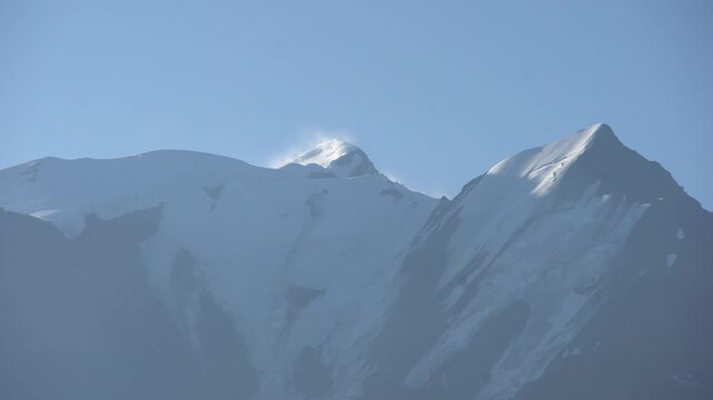 serene mountain range with snow-capped peaks under a clear sky in a wide-angle shot of rocky terrain for travel and adventure content