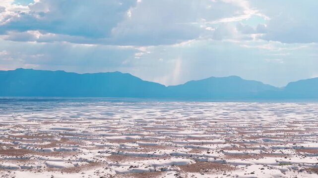bright white gypsum dune fields at White Sands National Park, New Mexico, displaying rolling wind-sculpted sand patterns under a bright sky aerial drone footage
