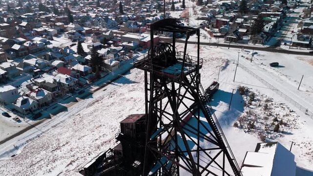 Low-altitude drone glide over Butte, Montana, highlighting historic industrial headframes and snow-covered terrain reflecting the region's prominent hard-rock mining heritage