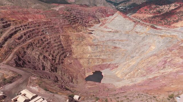 aerial drone of sprawling historic open-pit copper mining terraces carved into the desert terrain surrounding Bisbee, Arizona, highlighting rugged industrial heritage