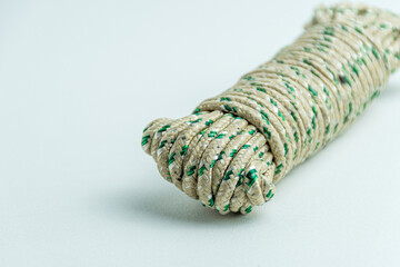 Rolled bundle of green and white twisted string rope isolated on white background © arbiwtm