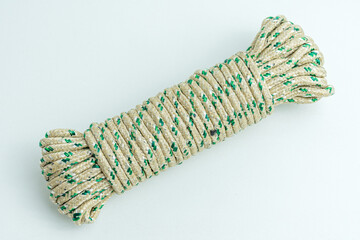 Rolled bundle of green and white twisted string rope isolated on white background © Arfin Studio