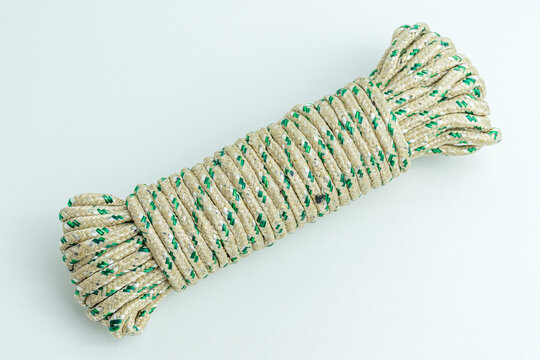 Rolled bundle of green and white twisted string rope isolated on white background