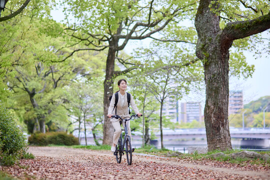 木々の間を自転車で移動する女性