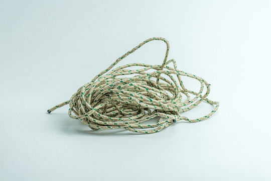 Messy tangled pile of green and white twisted string isolated on white background
