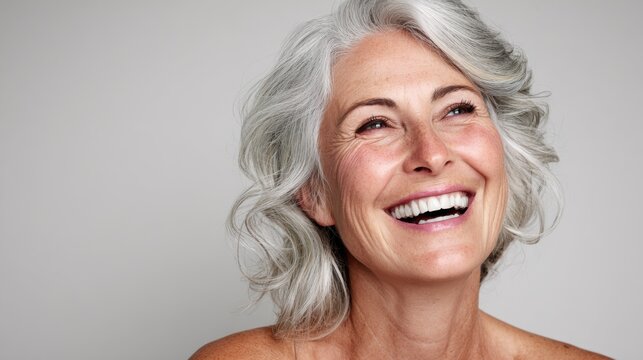 Senior woman smiling portrait, gray hair beauty close-up, joyful mature female face on clean background for wellness ads