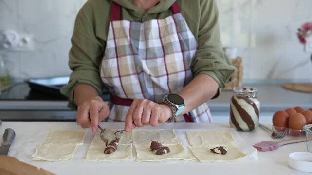 Woman Baking Cookies And Applying Chocolate Cream To The Pieces Of Dough