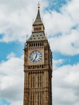 London, United Kingdom - 25 April 2023: View of Big Ben, the iconic clock tower with its intricate gothic architecture and clock face set against a blue sky with white clouds.