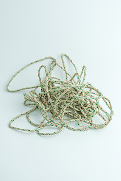 Messy tangled pile of green and white twisted string isolated on white background