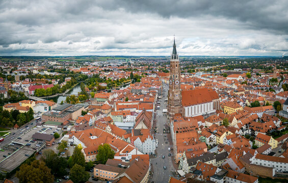 Landshut, Germany - 27 September 2022: View of St. Martin's Church rising above the historic red-tiled rooftops of Landshut, Germany, under a cloudy sky.
