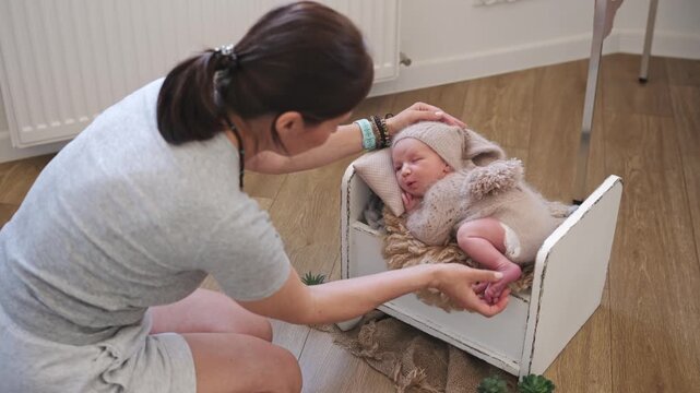 Newborn Photographer Gently Stroking The Baby Backstage At A Photoshoot